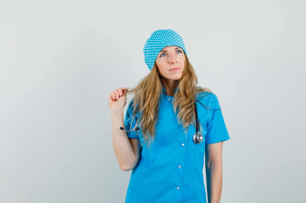 Female nurse in scrubs looking thoughtful, symbolizing a married nurse's secret side hustle and alternative income ideas