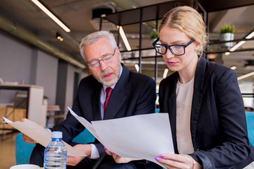 Two professionals reviewing financial documents in an office setting – FERS supplement retirement planning discussion